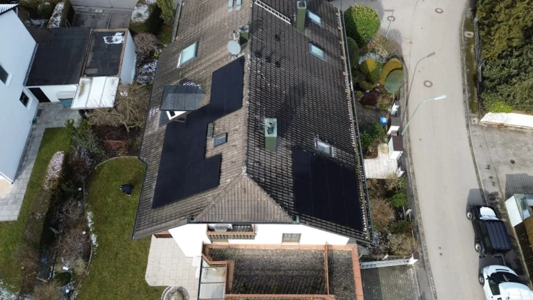Luftaufnahme: Photovoltaikanlage auf dem braunen Dach eines Einfamilienhauses