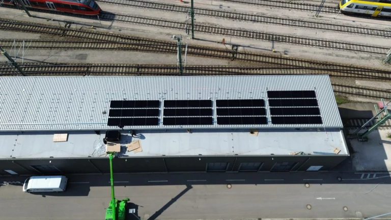 Luftaufnahme: Photovoltaikanlage auf einer Gewerbehalle, Montage mit Hubsteiger