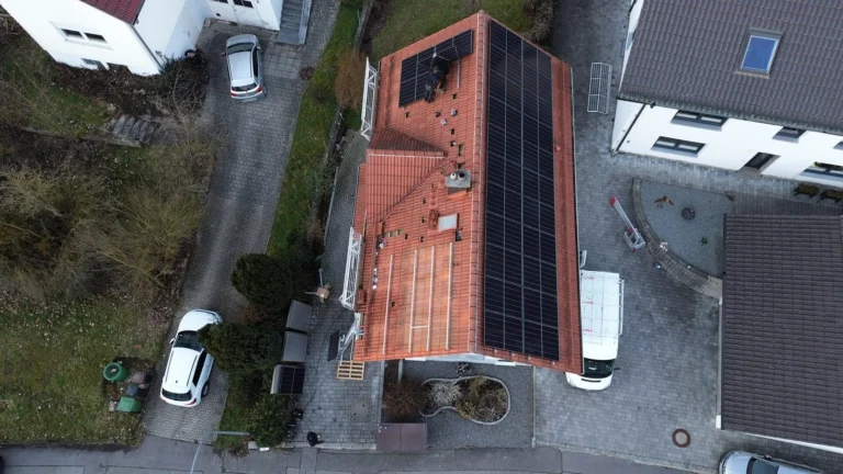 Luftaufnahme: Solarmodule auf dem langen Ziegeldach eines Wohnhauses