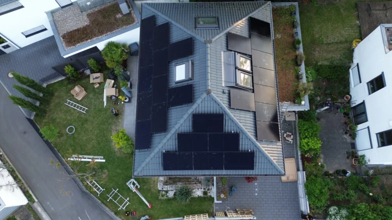 Luftaufnahme: Solarmodule auf mehreren Dachflächen eines Wohnhauses mit Garten
